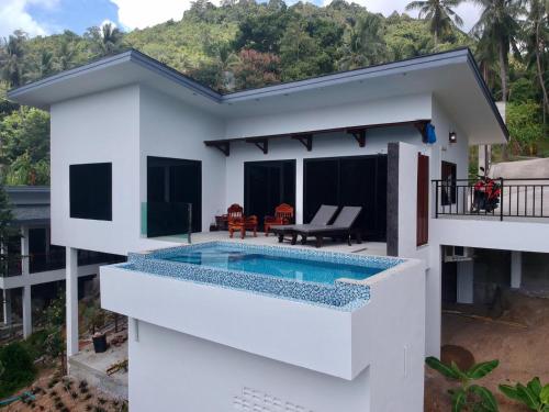 a white house with a swimming pool in front of it at 2 Bays Villa in Thong Nai Pan Yai