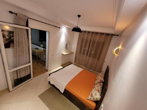 Habitación pequeña con cama y ventana en Bel appartement estival 2 chambres à Garden beach, en Sidi Rahal