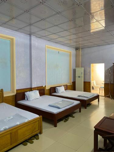 a room with three beds and a chalkboard on the wall at Nhà nghỉ FAMY in Móng Cái