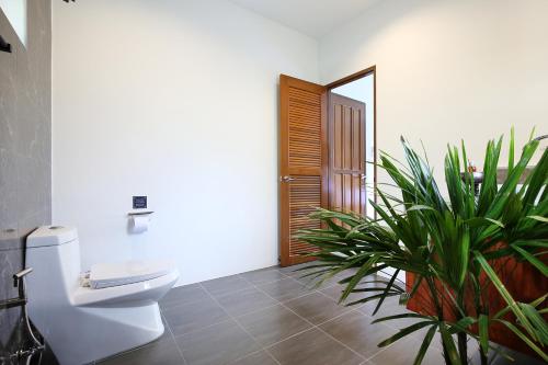 a bathroom with a toilet and a potted plant at 2 Bays Villa in Thong Nai Pan Yai