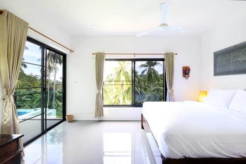 a bedroom with a bed and a large window at 2 Bays Villa in Thong Nai Pan Yai