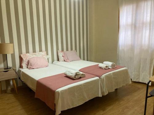 twee bedden met handdoeken bovenop in een kamer bij La casita de luis in Granada
