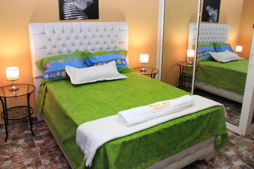 a bedroom with two beds with green sheets and a mirror at Stylish 1r-1b Apt Near The Beach And Main Street in Sosúa
