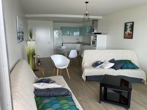 Il comprend un salon avec deux lits et une cuisine. dans l'établissement Superbe appartement accès mer et proche de tout, à Saint-Hilaire-de-Riez