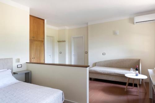 a bedroom with a bed and a couch and a table at Tenuta Lamborghini Golf & Resort in Panicale