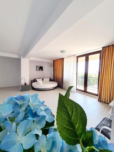 a room with a bed in the background with blue flowers at Coral Residence -Mamaia Nord in Mamaia