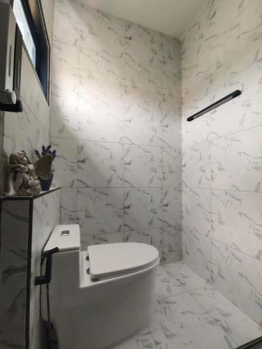 a bathroom with a white toilet and marble walls at H1boutique 