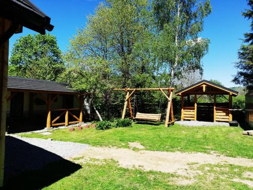 un parque con columpios y cenador en Dom - nad Potokiem, en Lutowiska