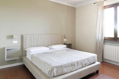 a bedroom with a bed and a window at Tenuta Lamborghini Golf & Resort in Panicale