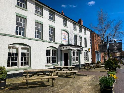 eine Gruppe Picknicktische vor einem Gebäude in der Unterkunft Cain Valley Hotel in Llanfyllin