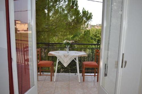 a table with a vase of flowers on a balcony at Studio Lantzos in Oreoi