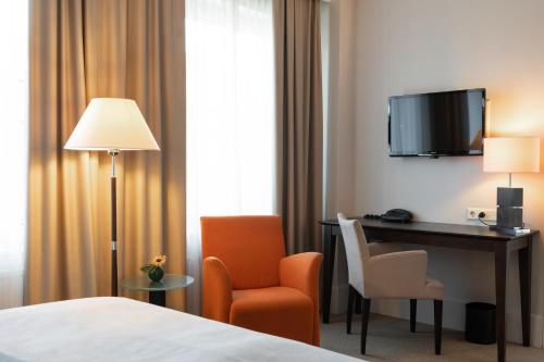 a hotel room with a bed and a desk and chair at Elite Palace Hotel & Spa in Stockholm