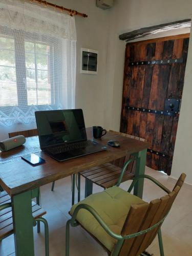 a laptop computer sitting on a wooden table in a room at The Cocoon and olives Hut in Koropi