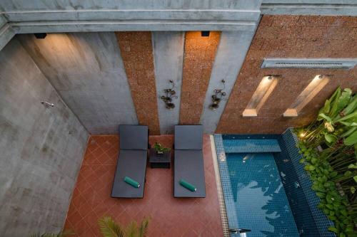 an overhead view of a pool with two chairs and a table at Grange in Siem Reap