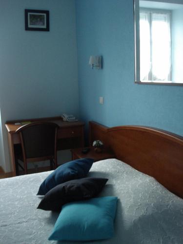 a bedroom with a bed with blue walls and pillows at Chambres d'hôtes la Chaumière in Arcy-sur-Cure