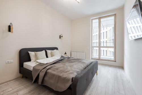 um quarto branco com uma cama grande e uma janela em InshiApartments on Pid Dubom 2 em Lviv
