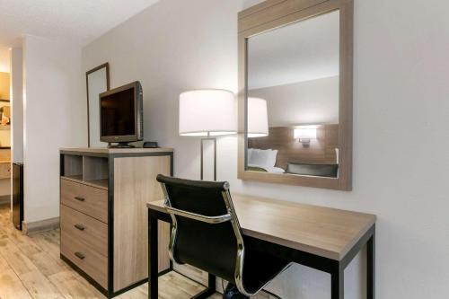 a room with a desk with a television and a mirror at Quality Inn St Augustine Outlet Mall in Saint Augustine