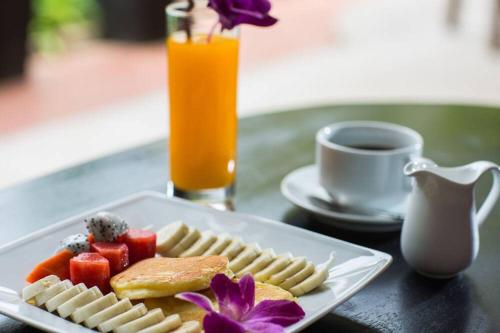 a plate of food on a table with a drink at Grange in Siem Reap