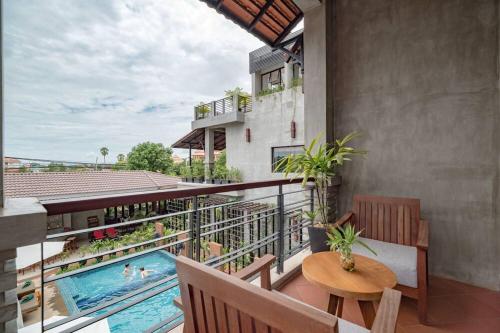 a balcony with a pool and a table and chairs at Grange in Siem Reap