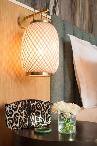 a table with a lamp and a vase of flowers on it at Hyatt Regency Taghazout in Taghazout