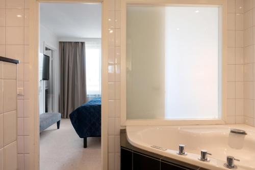a bathroom with a sink and a mirror at Elite Palace Hotel & Spa in Stockholm
