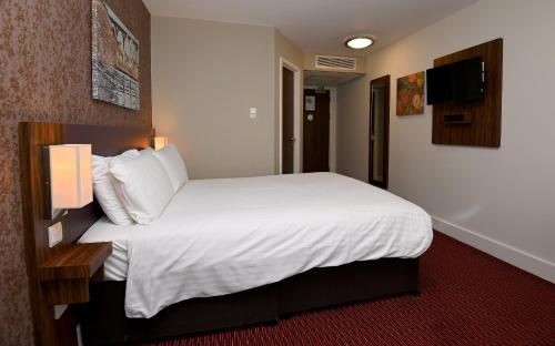 a hotel room with a large bed and a television at Penny Hedge, Whitby by Marston's Inns in Whitby