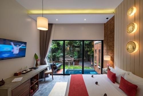 a bedroom with a large bed and a living room at Grange in Siem Reap