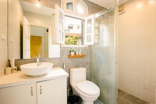 a bathroom with a toilet and a sink and a shower at Eden Westlake Hotel in Hanoi