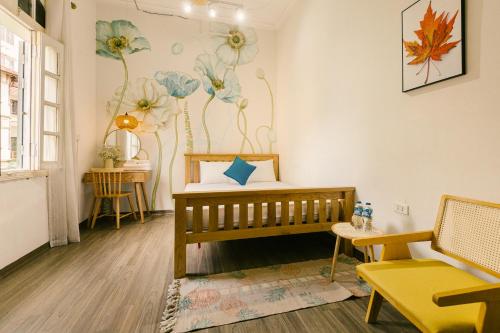 a room with a crib and flowers on the wall at Eden Westlake Hotel in Hanoi