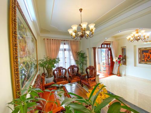 a living room with plants and a chandelier at Jolie Maison Đà Lạt in Da Lat