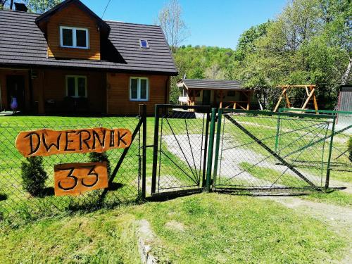 un cancello di fronte a una casa con un cartello sopra di Dom - nad Potokiem a Lutowiska