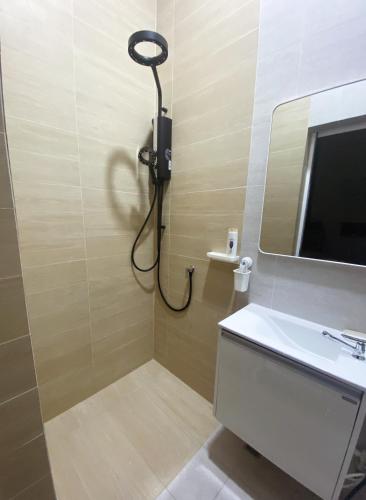 a bathroom with a shower and a sink and a mirror at Sundae Haus in Betong