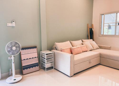 a small bedroom with a bed and a fan at Sundae Haus in Betong