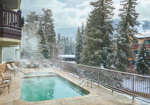 a swimming pool on a balcony with snow covered trees at Austria Haus Hotel in Vail