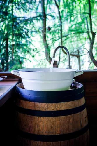 a white sink on a barrel with a faucet at Bylo Nebylo apartmány in Vítkovice