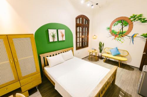 a bedroom with a bed and a green wall at Eden Westlake Hotel in Hanoi