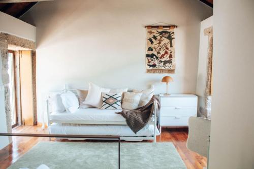 a living room with a white couch and a table at Just Like Home - Holly House em Cerveira in Linhares