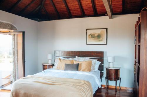 a bedroom with a large bed with a wooden headboard at Just Like Home - Holly House em Cerveira in Reboreda