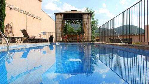 a swimming pool with a gazebo and blue water at Casa de vacaciones en Parque Nacional de Cabañeros in Navas de Estena