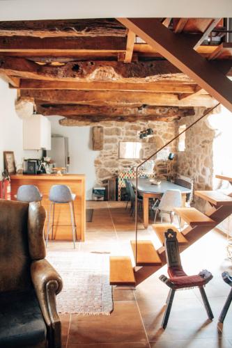 a living room with wooden ceilings and a table and chairs at Just Like Home - Holly House em Cerveira in Linhares
