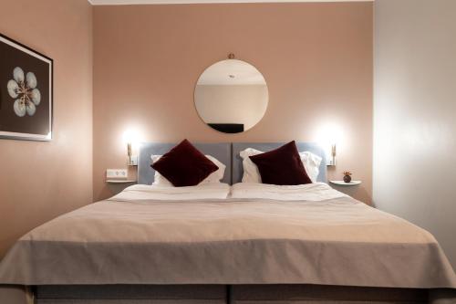 a bedroom with a large bed with a mirror on the wall at Elite Palace Hotel & Spa in Stockholm