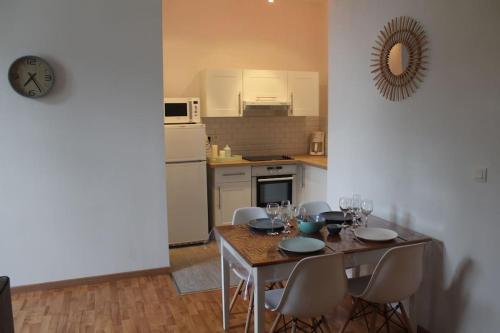 una cocina con mesa y sillas con copas de vino en Appartement calme proche de la Loire, en Saumur