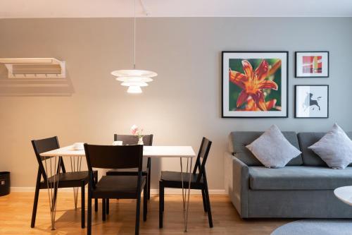 a dining room with a table and a couch at Elite Palace Hotel & Spa in Stockholm