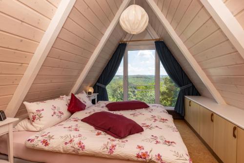 a bed in a room with a large window at Ferienhaus Düperthal in Hilchenbach