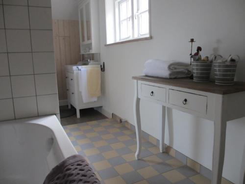 La salle de bains est pourvue d'une baignoire et d'un lavabo. dans l'établissement B&B Boerderij Wijtvliet, à Langeweg