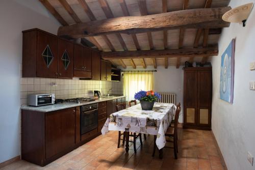 a kitchen with wooden cabinets and a table with chairs at Agriturismo Sacchiafarm in Borgo Pace