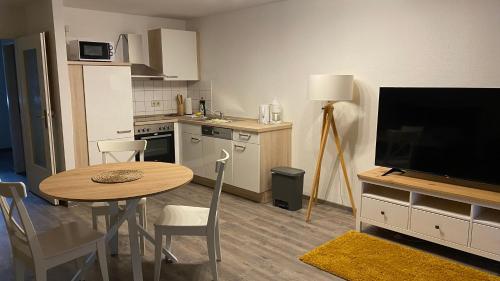 a kitchen with a table and a television and a table and chairs at City-Appartement 12.4. in Zwickau