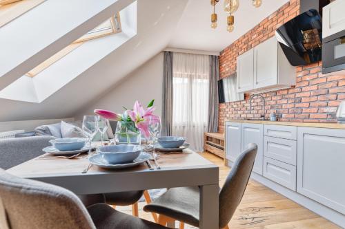 a kitchen and dining room with a table and chairs at Karkonoski Klimat - apartamenty z sauną, balią i jacuzzi in Miłków