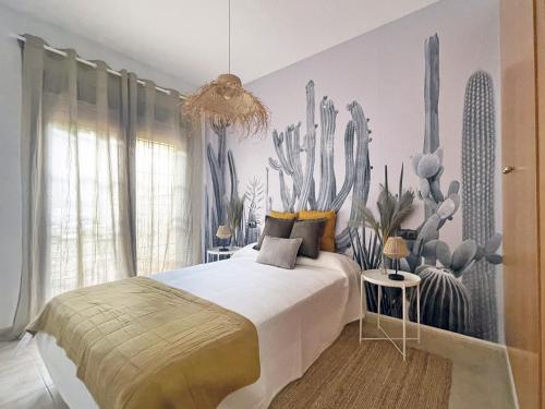 ein Schlafzimmer mit einem Bett mit einem Kaktus-Wandbild in der Unterkunft Apartamentos Brisas del Puerto de Aguadulce in Aguadulce