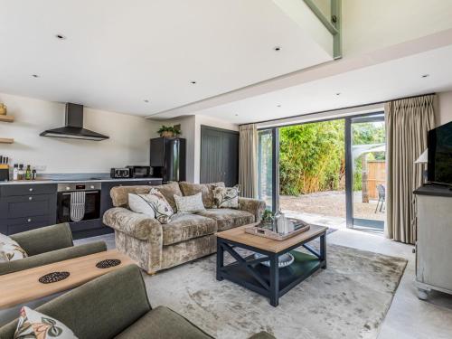 a living room with a couch and a table at Pass the Keys Peaceful And Beautiful Barn In Downland Village in Chichester
